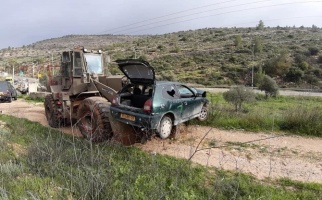 An Israeli bulldozer transporting the confiscated Palestinian car after the accident