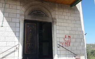 Burnt front door of Al-Sheikh Sa’da Mosque and graffiti in Hebrew on the wall – Photo taken on 16 April 2018, Al-Haq © 2018.